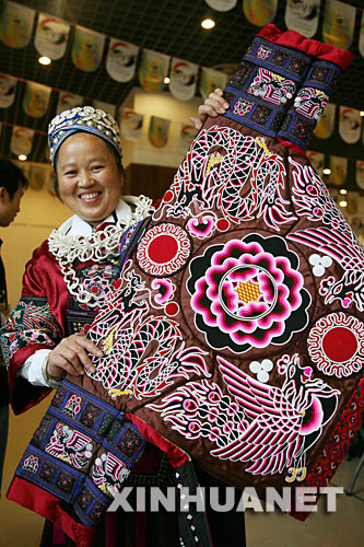 10月9日,苗族妇女王金花展示一件标价8万元的苗族刺绣盛装。 当日,在2007多彩贵州旅游商品设计大赛和旅游商品制作能工巧匠选拔大赛总决赛上,来自凯里市的苗族妇女王金花手工制作的一件精美刺绣苗装标出8万元的高价,吸引了众多参赛者和市民的眼球。据介绍,这件苗族盛装采用叠绣、平绣、扁带绣、打籽绣、挑绣等多种绣法,以太阳、龙、凤、蝴蝶等为题材,为苗绣中的精品。