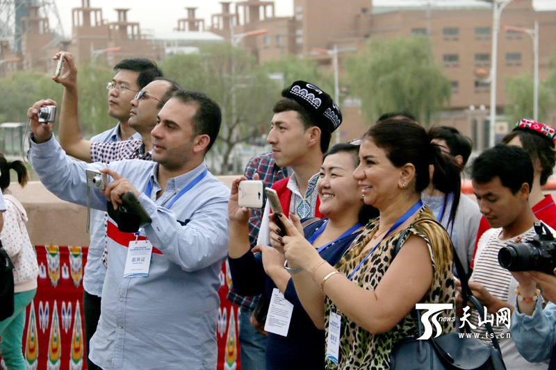 “丝绸之路经济带相关国家媒体负责人研修班”学员走进喀什老城区,摄像机、相机、手机齐上阵。